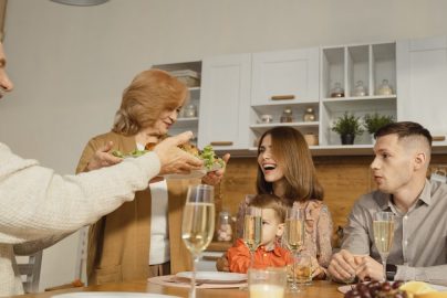 A multigenerational family enjoying a festive dinner indoors, sharing joy and togetherness.